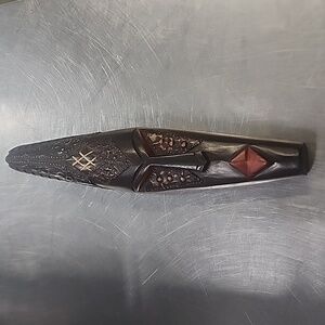 Ornate wood and metal wall mask display.